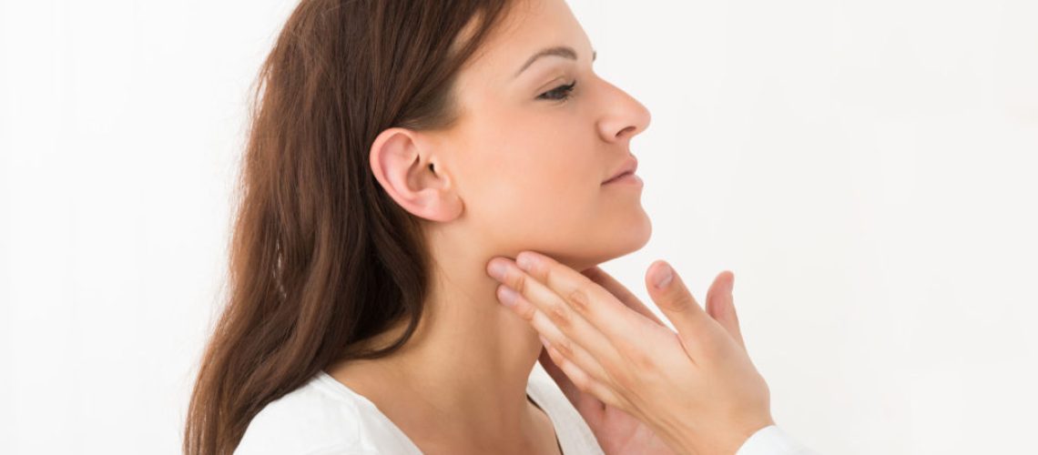 Close-up Of A Doctor's Hand Touching The Throat Of A Female Patient In The Clinic